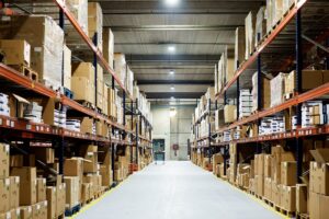 Empty warehouse, view down the asile with shelves and boxes.